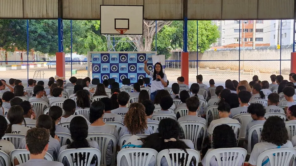 Público reunido em ação educativa em quadra coberta